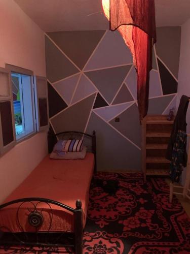 a bedroom with a bed with a geometric wall at Ocean Jam Surf House in Agadir