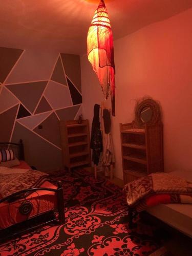 una camera con due letti e un lampadario a braccio di Ocean Jam Surf House ad Agadir