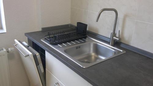 a kitchen sink with a laptop on top of it at Unseburg-Ferienwohnung 4 