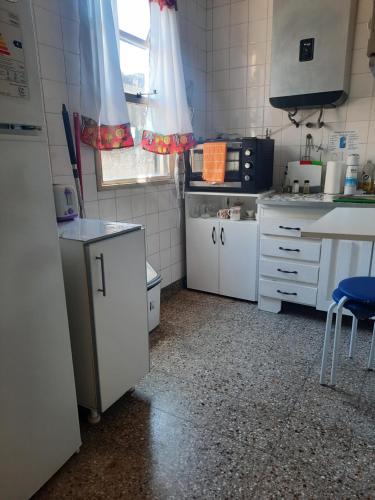 a small kitchen with white cabinets and a sink at Vivi la mejor experiencia en el corazon de BA !!!! in Buenos Aires