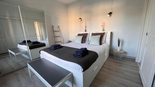 a bedroom with a large bed and a mirror at Appartement vue mer à Pontaillac in Royan