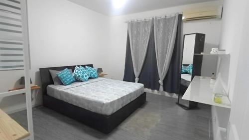 ein Schlafzimmer mit einem Bett mit blauen Kissen und einem Spiegel in der Unterkunft Last Moon in Flic-en-Flac