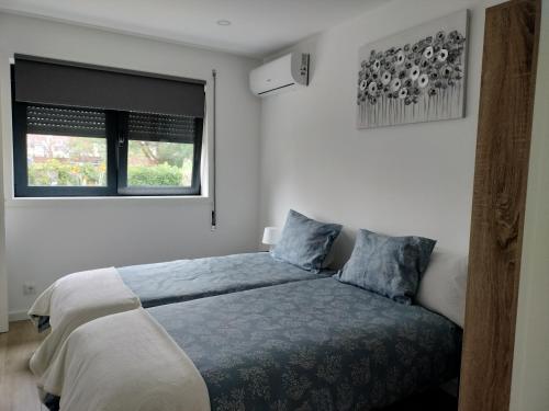 sypialnia z łóżkiem i oknem w obiekcie Alojamento Andorinhas w mieście Senhora da Hora