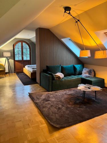 a living room with a green couch and a bed at Villa am Grossen Garten in Dresden