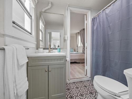 uma casa de banho com um lavatório, um WC e um espelho. em Oceanfront Paradise - Spa, Pet-Friendly, Fast Wifi, Parking & Dream Views em San Diego