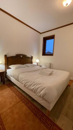 un grand lit dans une chambre avec une fenêtre dans l'établissement Les Comtes de Savoie - Appartement rénové proche du centre de Megève avec vue sur le Mont d'Arbois, à Megève