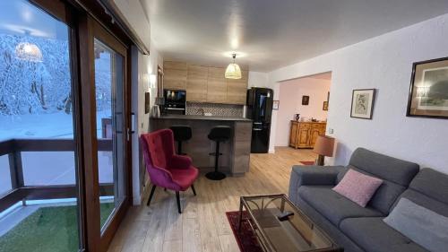 a living room with a couch and a kitchen at Les Comtes de Savoie - Appartement rénové proche du centre de Megève avec vue sur le Mont d'Arbois in Megève