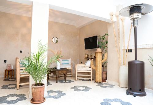- un salon avec une table, des chaises et une télévision dans l'établissement Riad21, à Marrakech