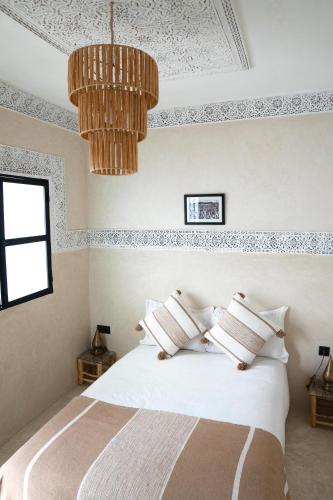 a bedroom with a bed and a chandelier at Riad21 in Marrakesh
