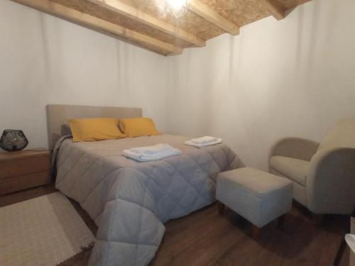 - une chambre avec un lit doté d'un oreiller jaune et d'une chaise dans l'établissement Casa Tia Vina, à Arouca
