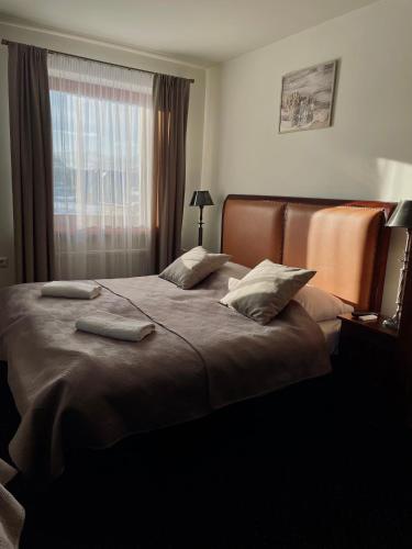 a bedroom with a bed with two pillows and a window at Sarenka in Białka Tatrzańska