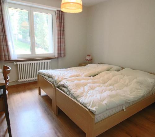 a bedroom with a bed in a room with a window at Appartement Mittaghorn Saas-Fee in Saas-Fee
