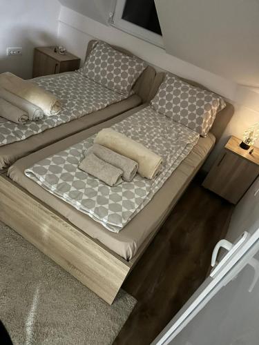 a bed with two pillows on it in a room at Cottage Nena Tara in Kaludjerske Bare