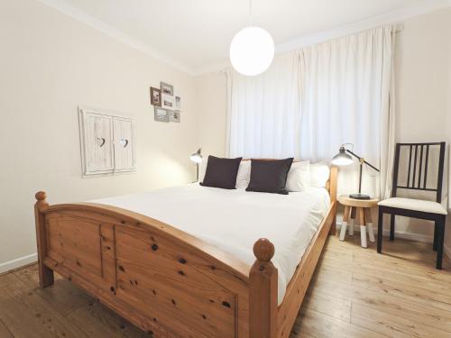 a bedroom with a large wooden bed and a chair at Newly Refurbished in Town Center in St Andrews