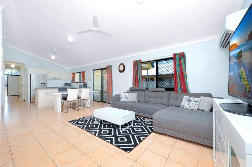 ein Wohnzimmer mit einem Sofa und einem Tisch in der Unterkunft Beautiful Home stay in Townsville in Rosslea