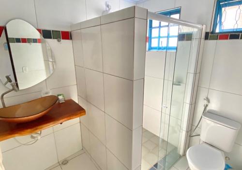 a bathroom with a sink and a toilet and a mirror at Pousada Praias do Norte in São Miguel dos Milagres