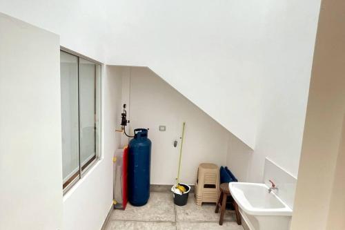 ein Badezimmer mit einem großen blauen Wassertank neben einem Waschbecken in der Unterkunft Alojamiento en Chilca - Puerto Viejo in Salinas