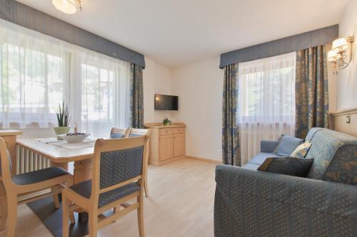 a living room with a table and a dining room at Garnì La Dorada in Colfosco