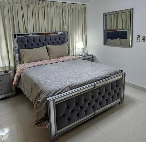 una camera con un grande letto e uno specchio di Torre jeshua a Santo Domingo