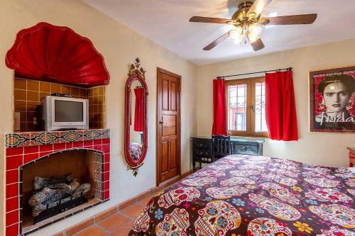 a bedroom with a bed with a fireplace and a tv at San Miguel Actor's Studios in San Miguel de Allende