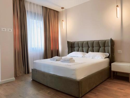 een slaapkamer met een groot bed en een groot raam bij Apartments Premium Center Tirana in Tirana