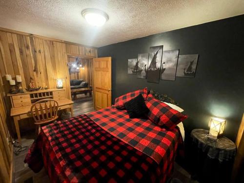 a bedroom with a red and black checkered bed at Getaway to a very private beautiful Cabin. in Kyles Ford