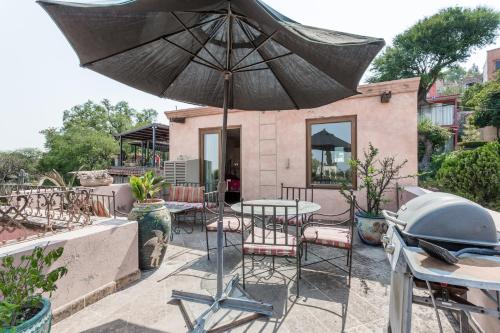 a patio with a table and chairs and an umbrella at Casa de la Vista in San Miguel de Allende
