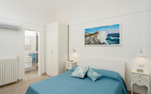 a bedroom with a blue bed and a painting on the wall at Caprita Guest House in Anacapri