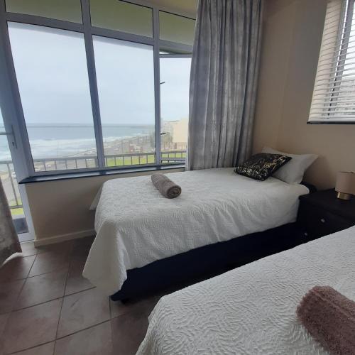 a bedroom with two beds and a large window at Kennaway Court in East London