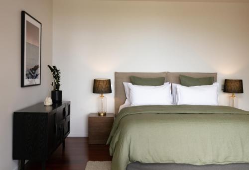 a bedroom with a large bed with white pillows at Okoro Villa in Nelson