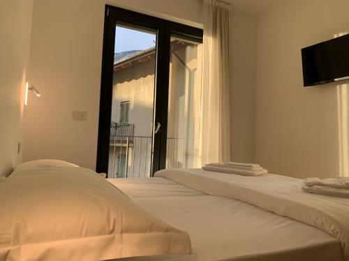 a bedroom with two beds and a large window at Bernina Suite 2 - vicino al Bernina Express in Tirano