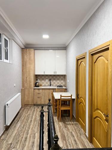 a kitchen with a table and a kitchen with white cabinets at Highland Kazbegi in Stepantsminda