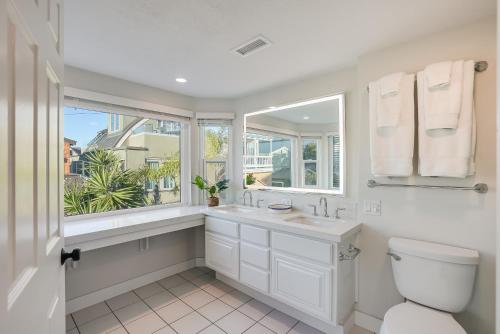 a bathroom with a toilet and a sink and a window at Beautiful Beach Home - Ocean View, AC & Patio in San Diego