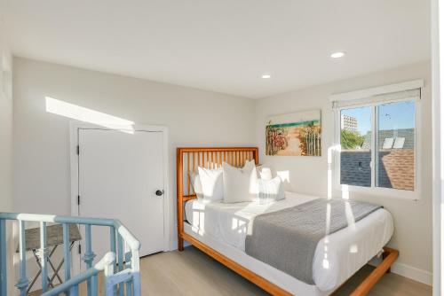 a white bedroom with a bed and a window at Beautiful Beach Home - Ocean View, AC & Patio in San Diego