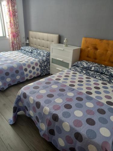 a bedroom with two beds and a dresser at Apartamento en Tenerife Islas Canarias in Candelaria