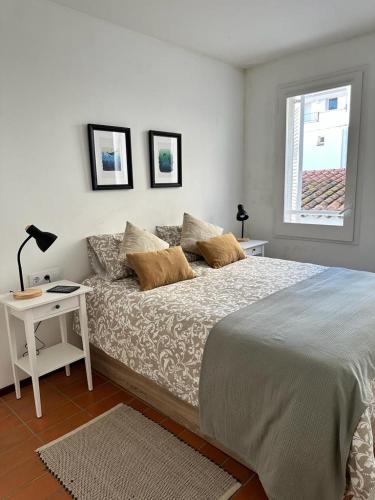 um quarto com uma cama, uma mesa e uma janela em RACO DE SES OLIVERES em Cadaqués