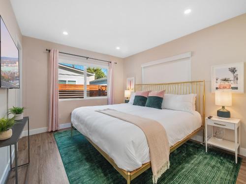a bedroom with a large bed and a large window at Classic Beach Bungalow - Parking, Private Patio & Pet Friendly! in San Diego