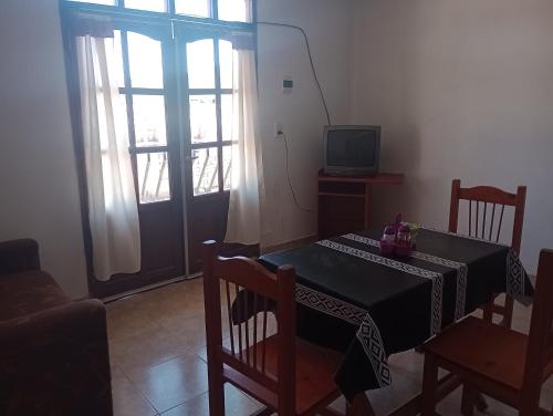 a dining room with a table and chairs and a television at Doña Guada in Humahuaca