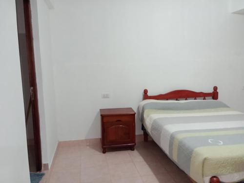 a bedroom with a bed and a night stand next to it at Doña Guada in Humahuaca