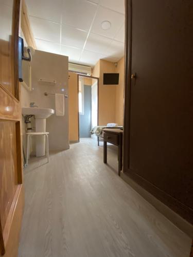 a room with a bathroom with a sink and a door at LÀtic Rooms in Alicante