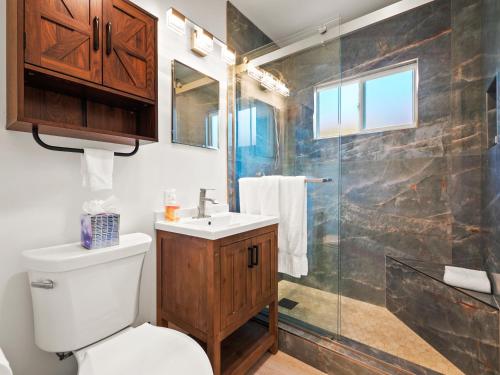 a bathroom with a shower and a toilet and a sink at Bay Park Garden Paradise - central Location, AC, Washer Dryer & Private yard! in San Diego
