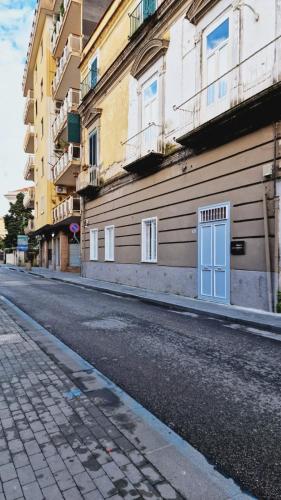 a building with a blue door on the side of a street at Miambra in Grumo Nevano