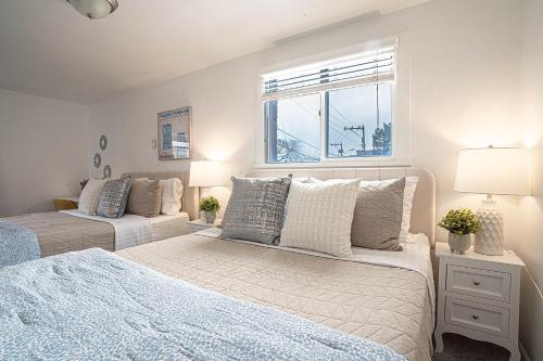 1 dormitorio con 2 camas y ventana en Seaside Serenity 1-BR Apt with peek-a-boo sound views, en Seattle