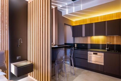 a kitchen with black cabinets and a sink and a chair at La Pergola Suites in Dossobuono