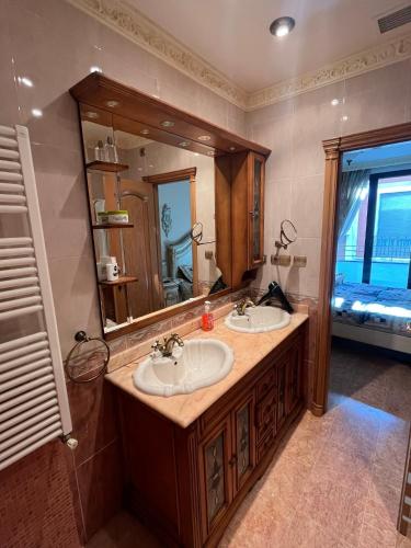 een badkamer met 2 wastafels en een grote spiegel bij Suite en el centro de Elche in Elche