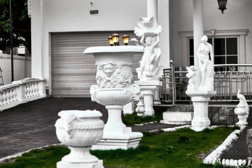 a group of white statues in front of a house at The Peacock Mansion in Kumasi