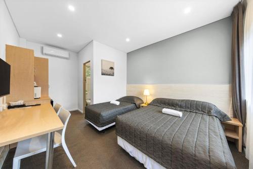 Pokój hotelowy z łóżkiem i biurkiem w obiekcie Westside Motor Inn w mieście Sydney