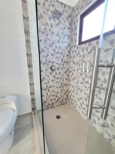 a bathroom with a shower with a toilet and a window at Casa Teques con aire acondicionado in Tequesquitengo