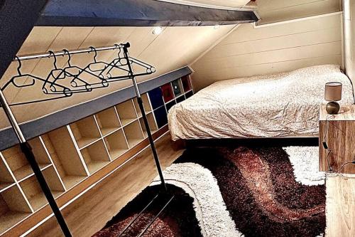 Appartement duplex à Chantilly centre في شانتيلي: غرفة نوم صغيرة مع سرير بطابقين وسجادة