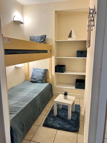 Cette petite chambre comprend des lits superposés et une table. dans l'établissement Nice Appartement en Bord de Mer avec Piscine - Jusqu'à 6 Personnes, à Nice
